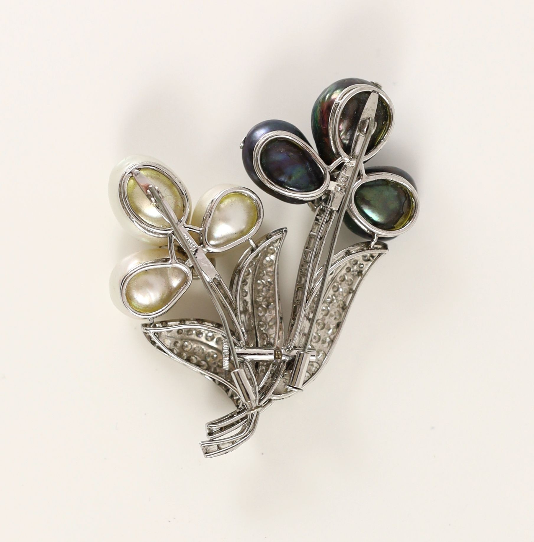 A 20th century platinum, baroque cultured and Tahitian pearl, round and baguette cut diamond cluster set spray brooch